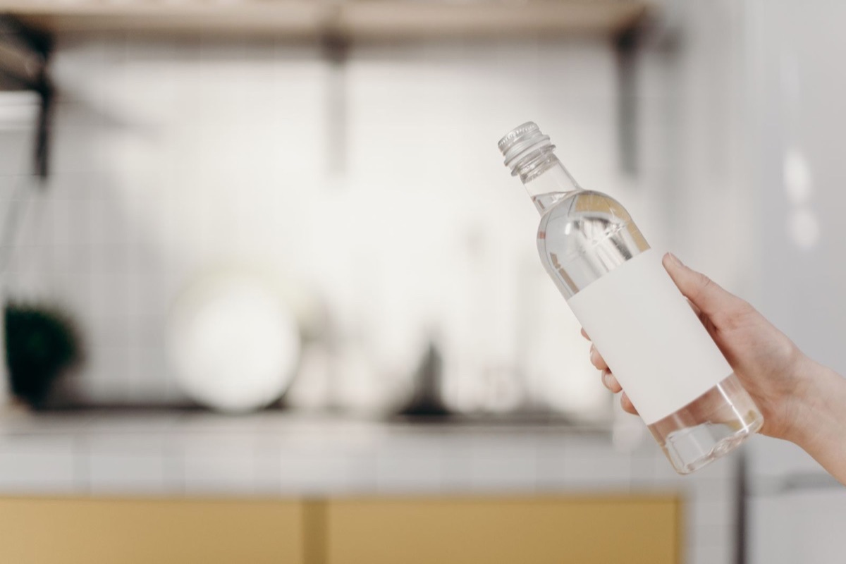 Botella transparente con etiqueta blanca rectangular